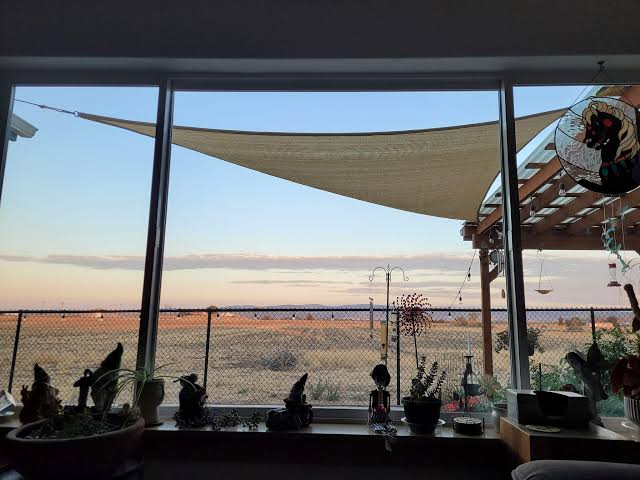 High desert view from a patio at dusk, seen through a clean window